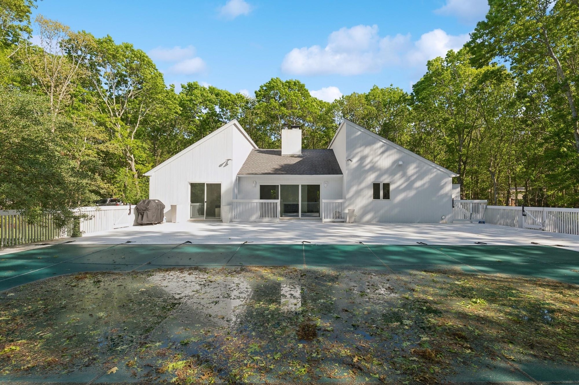 Rear view of house with a patio, a chimney, and a gate