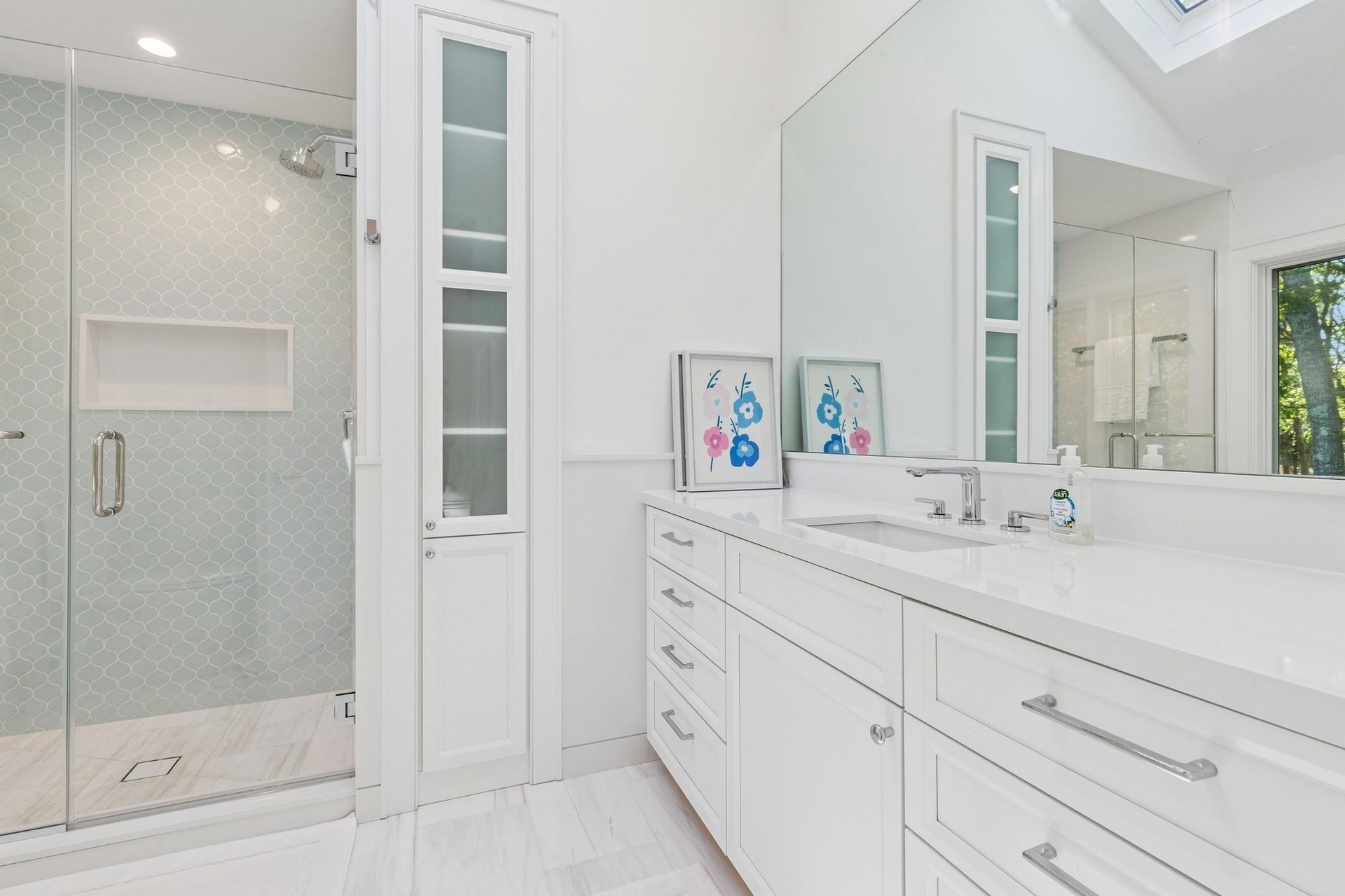 Full bath featuring a skylight, vanity, a stall shower, marble look tile flooring, and recessed lighting
