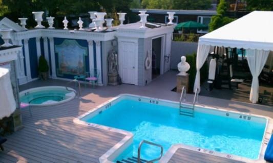 Community pool featuring a community hot tub, a gazebo, a wooden deck, and a patio