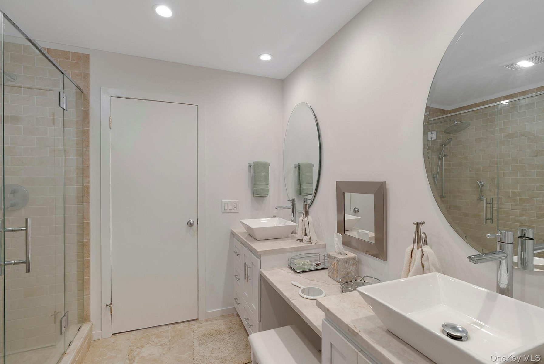 Full bath with a stall shower, double vanity, and recessed lighting