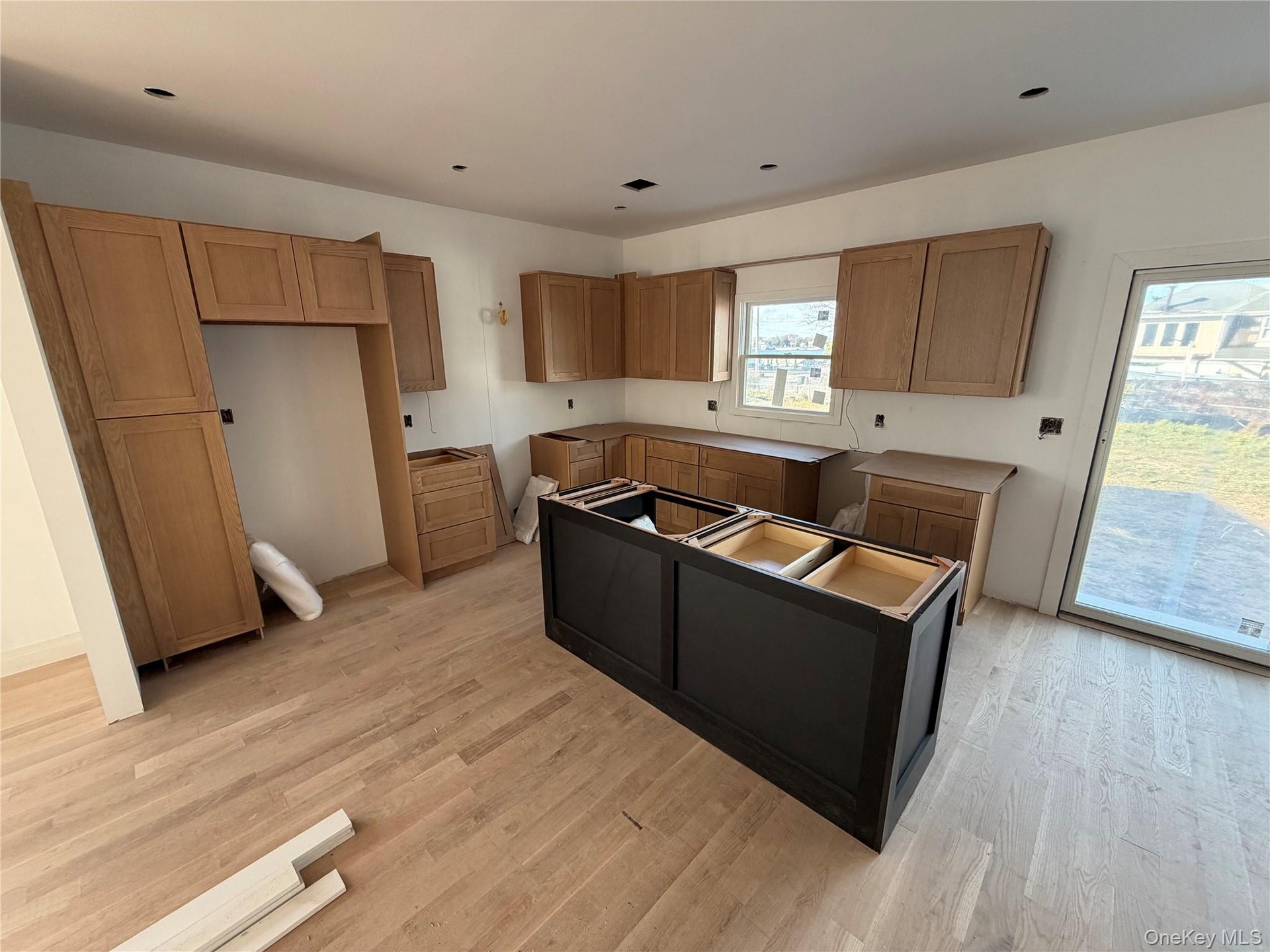 Kitchen featuring light wood-type flooring, brown cabinets, and a center island
