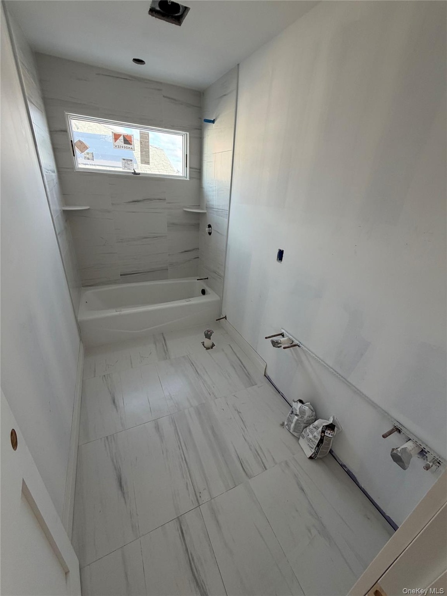 Full bathroom featuring shower / washtub combination and baseboards