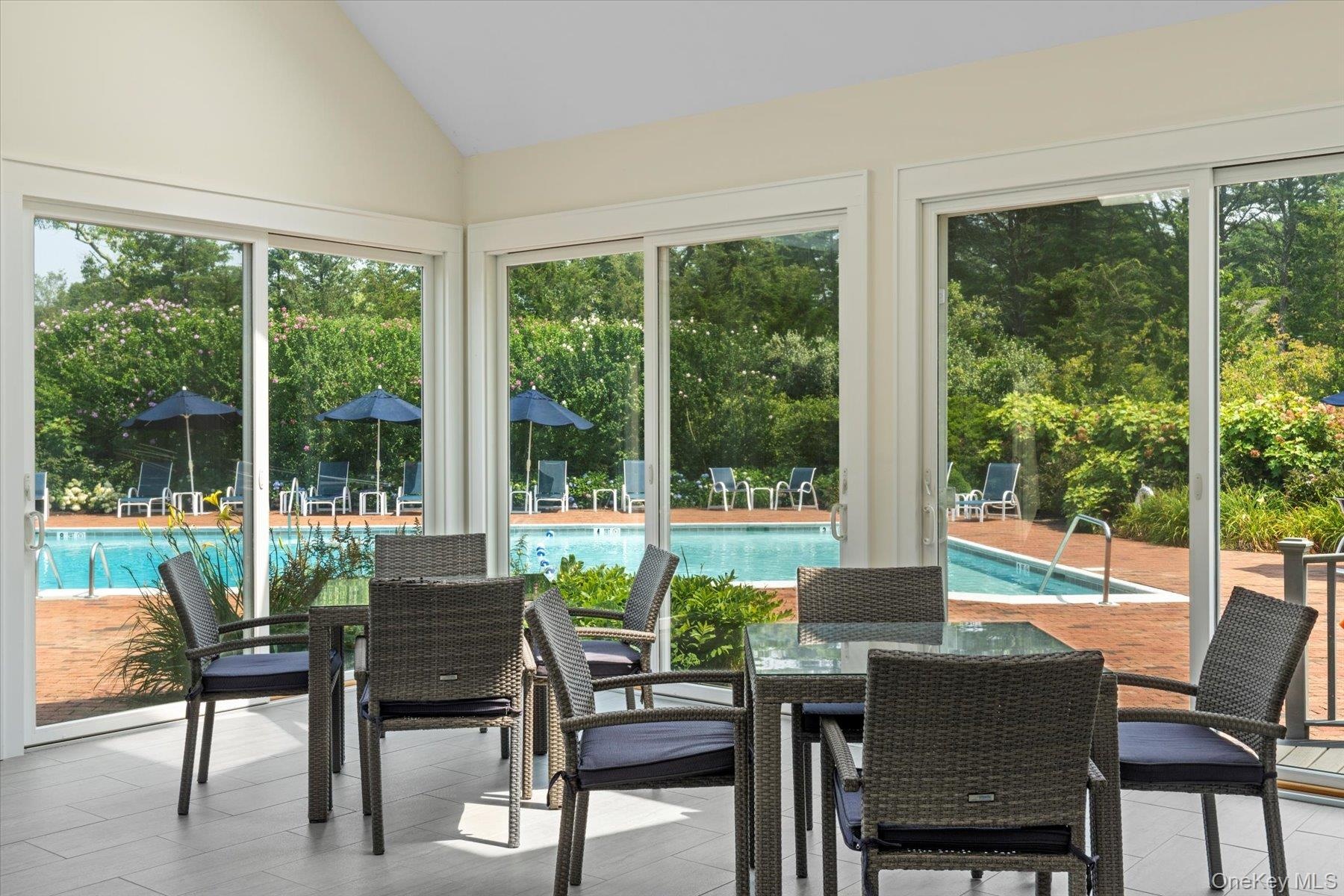 Sunroom / solarium with vaulted ceiling and view of scattered trees
