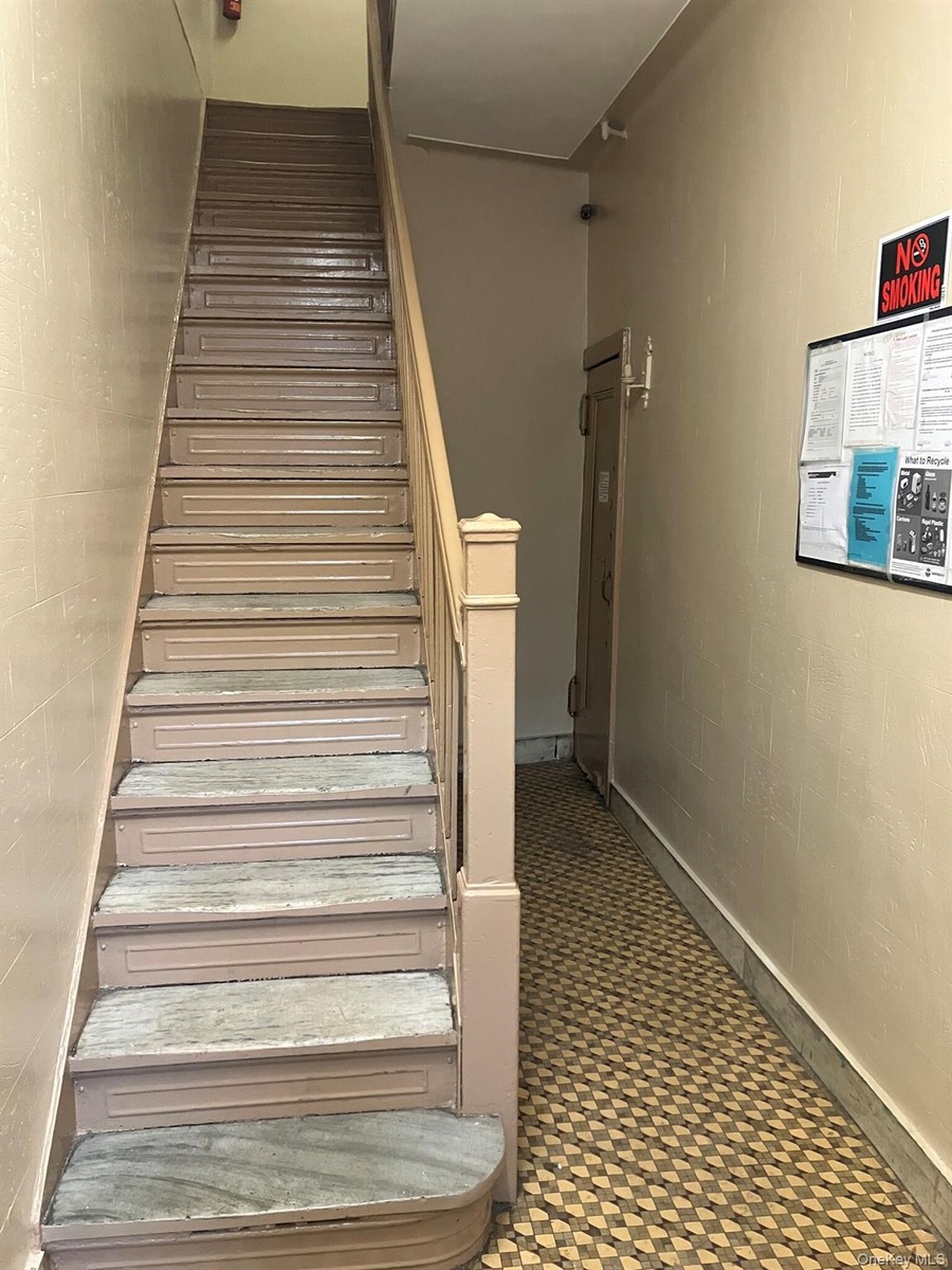 Staircase featuring concrete block wall
