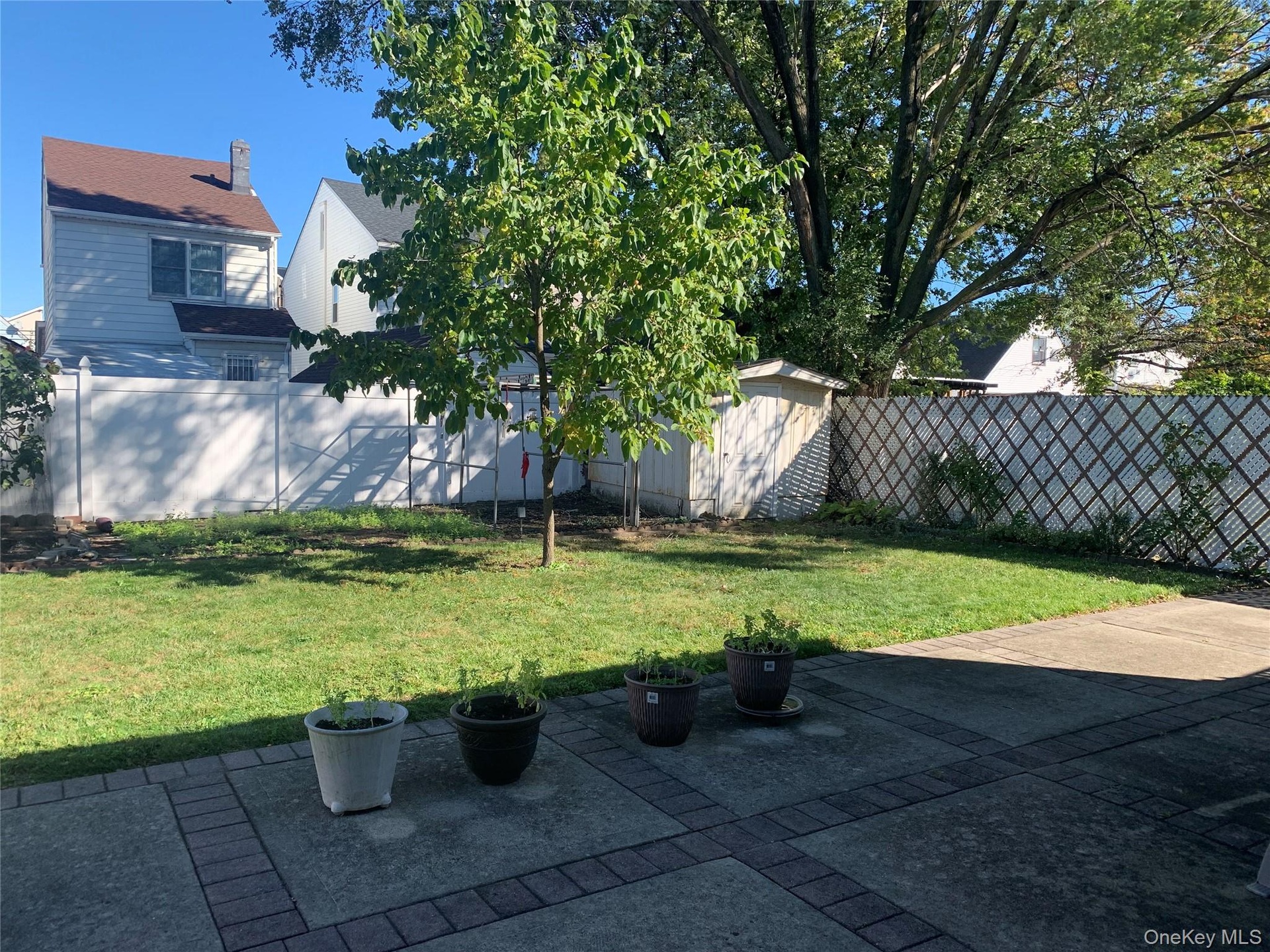 Fenced backyard featuring a storage shed and a patio