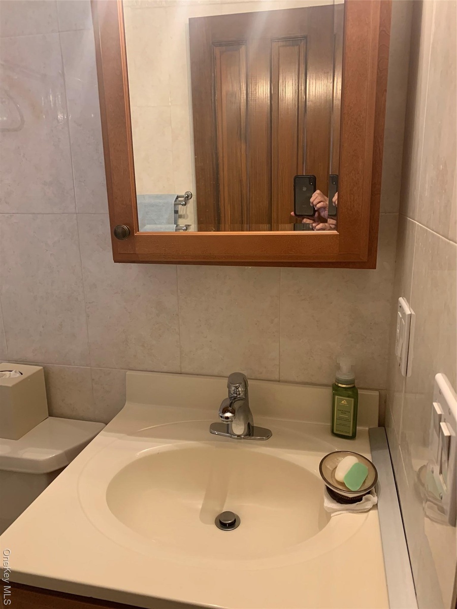 Bathroom featuring vanity and tile walls