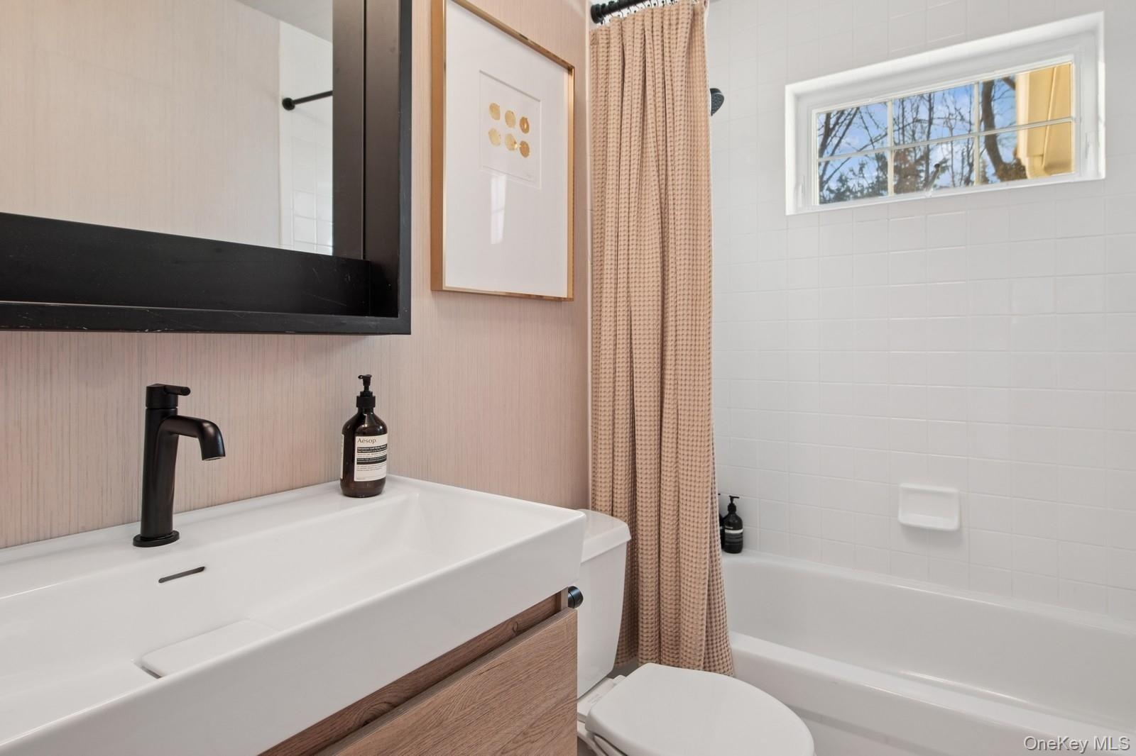 Full bath featuring vanity and shower / bathtub combination with curtain