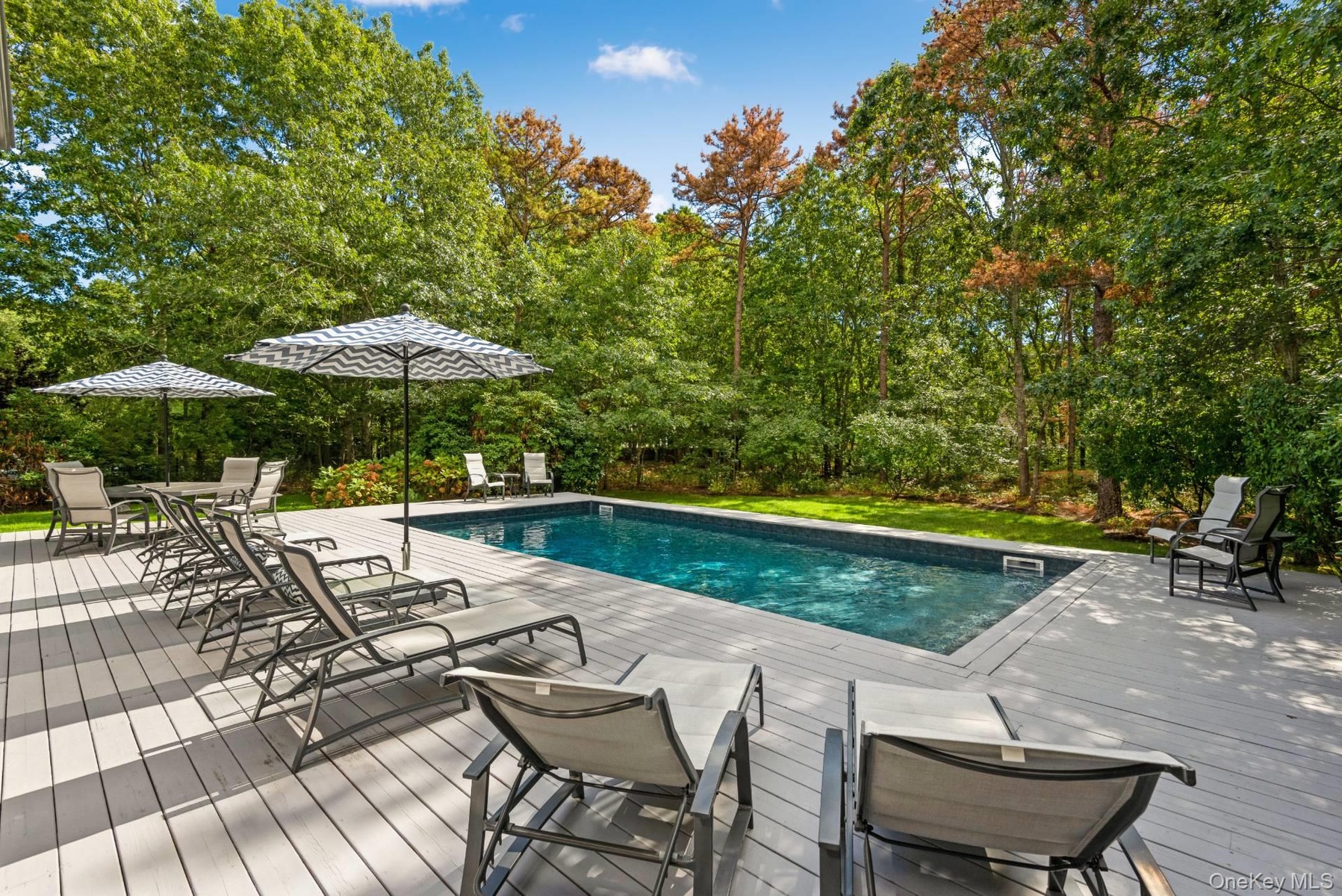 Outdoor pool featuring a wooden deck and a patio