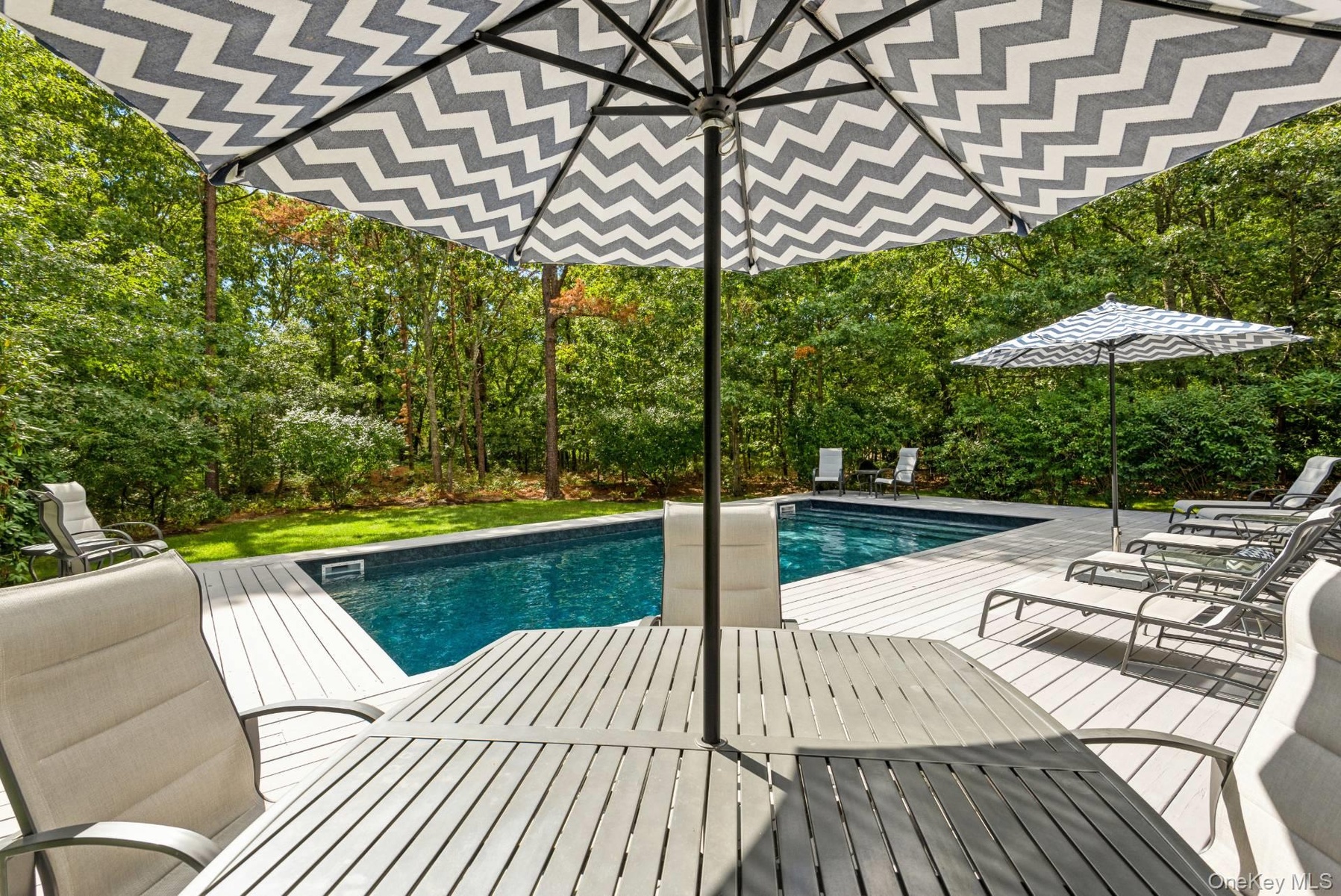 Outdoor pool featuring a deck and outdoor dining area