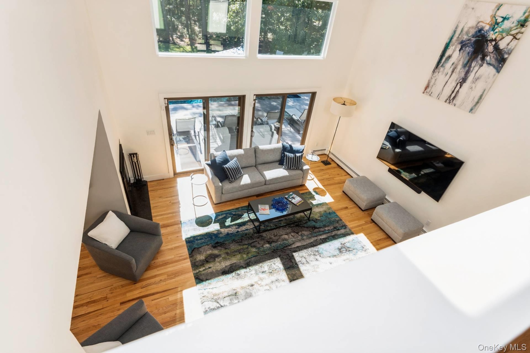 Living room with light wood finished floors and a high ceiling