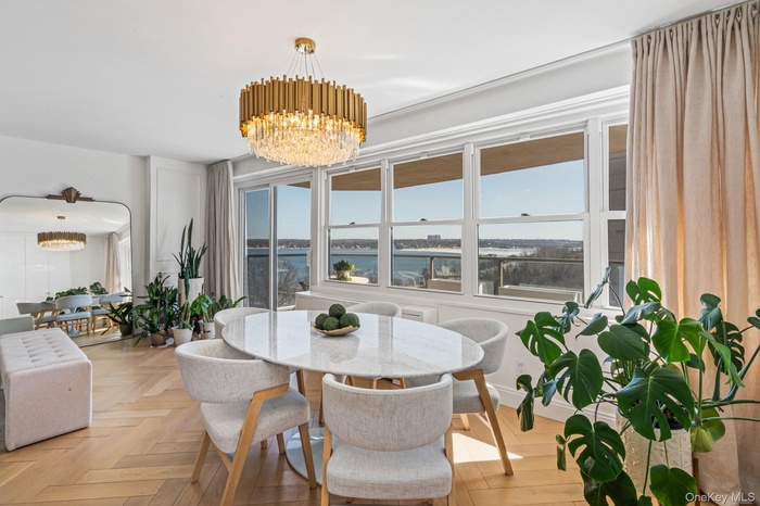 Dining space featuring herringbone parquet flooring, suspended lighting, and a water view