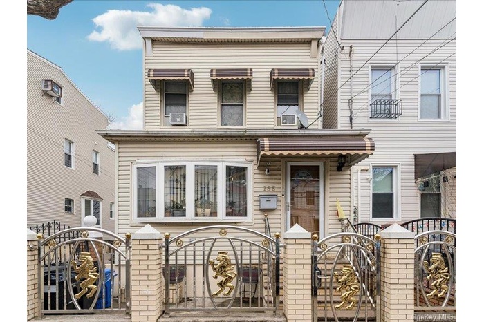 View of front of house with a fenced front yard and a gate