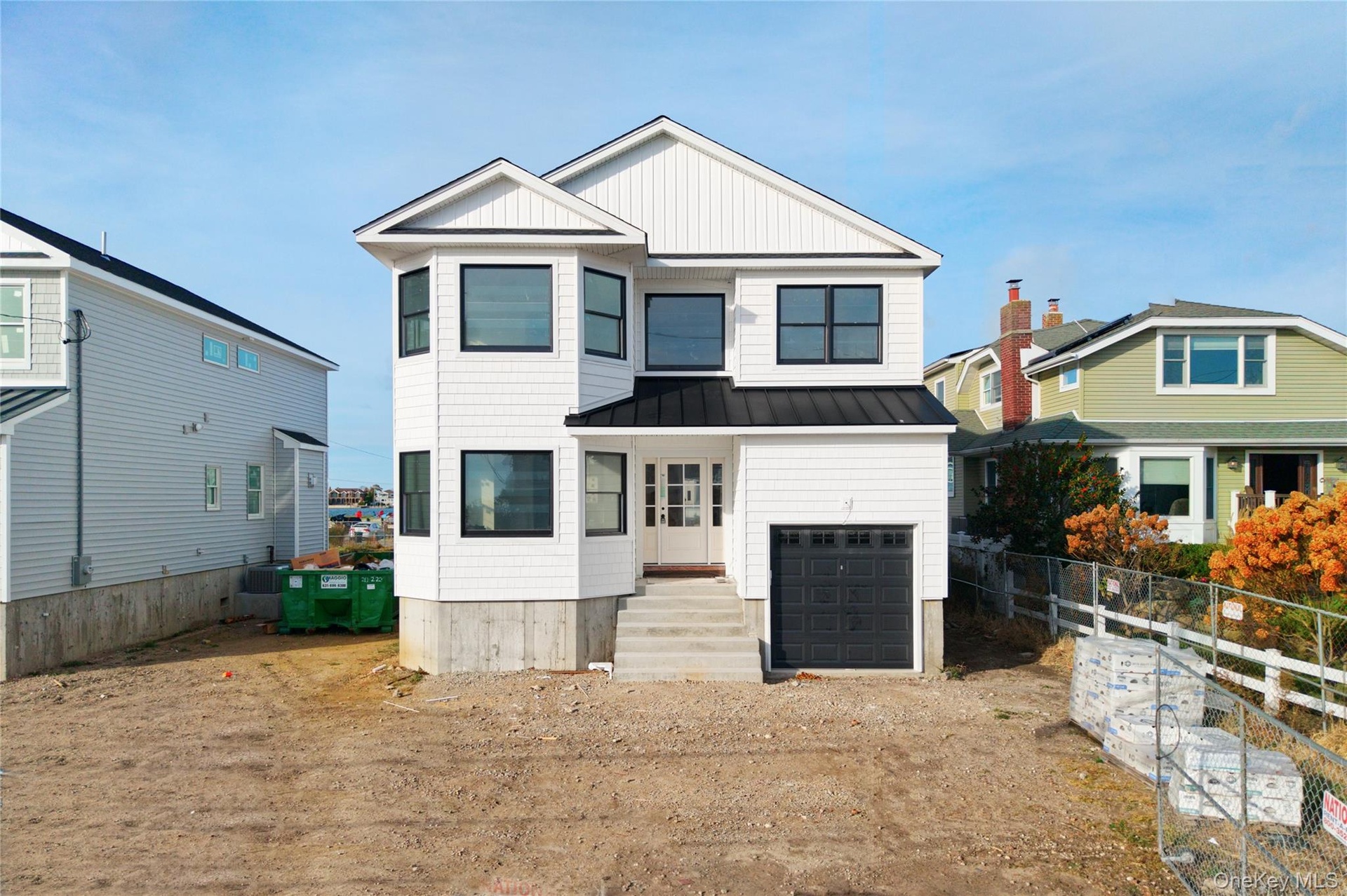 View of front of property with a standing seam roof, a metal roof, board and batten siding, and a garage