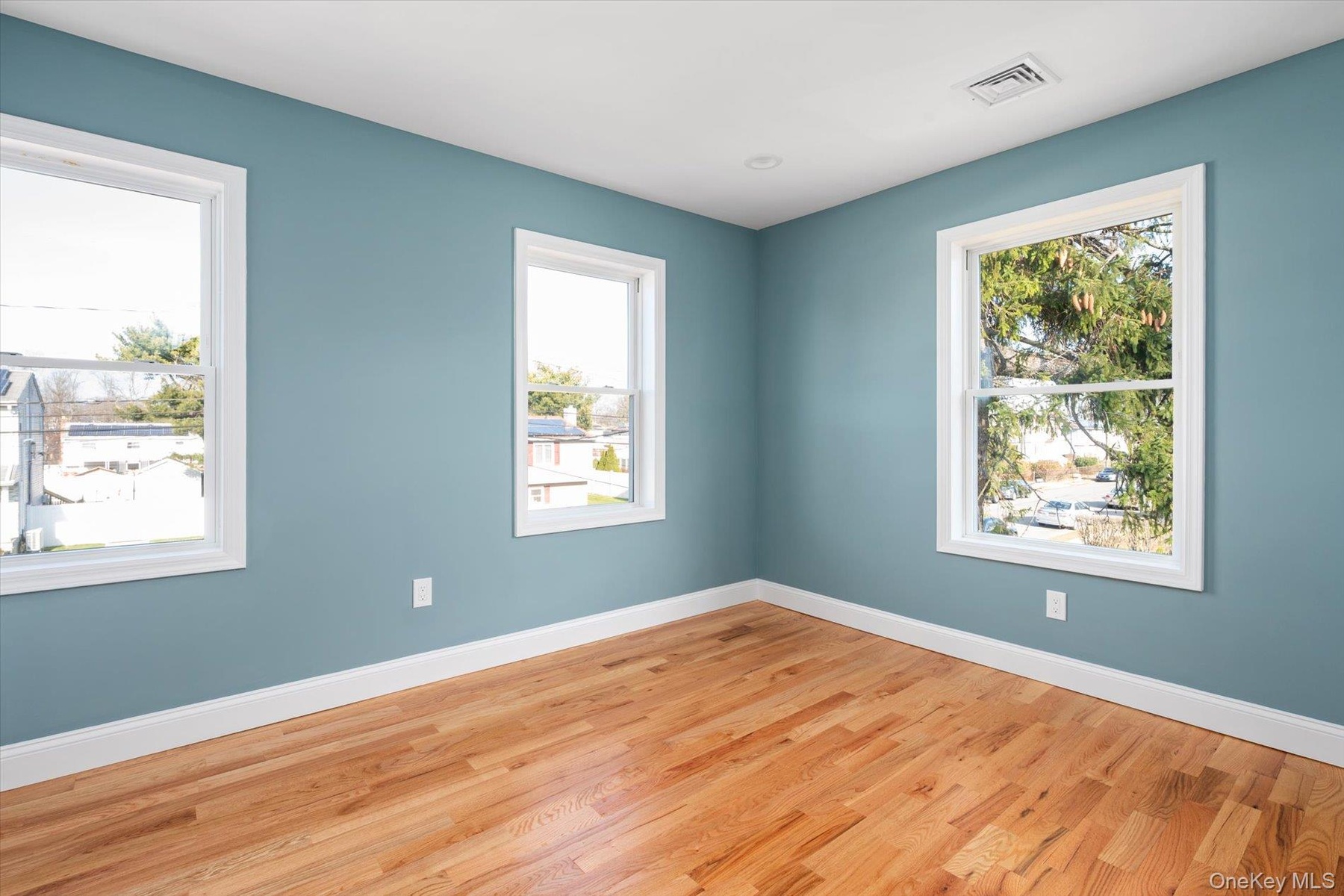 Empty room with wood finished floors and plenty of natural light