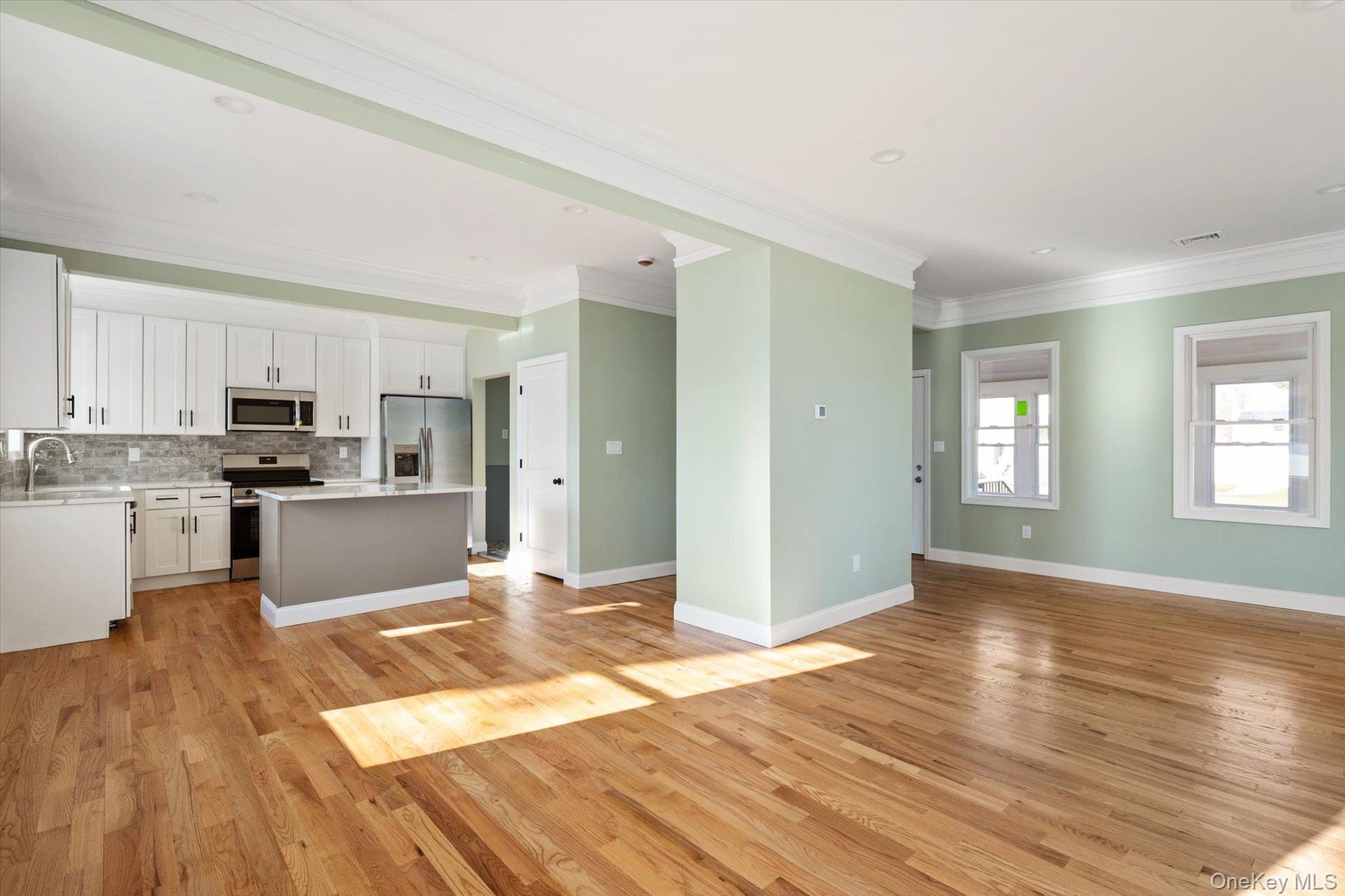 Unfurnished living room with crown molding, light wood finished floors, and recessed lighting