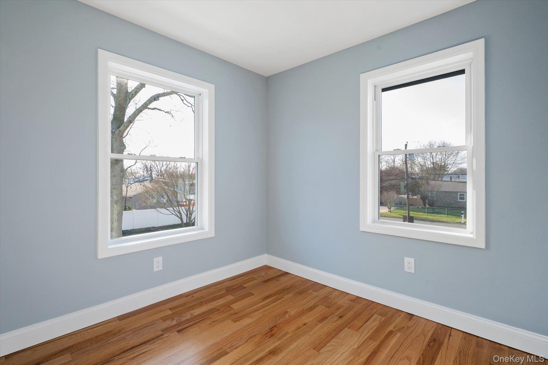 Unfurnished room featuring wood finished floors and baseboards