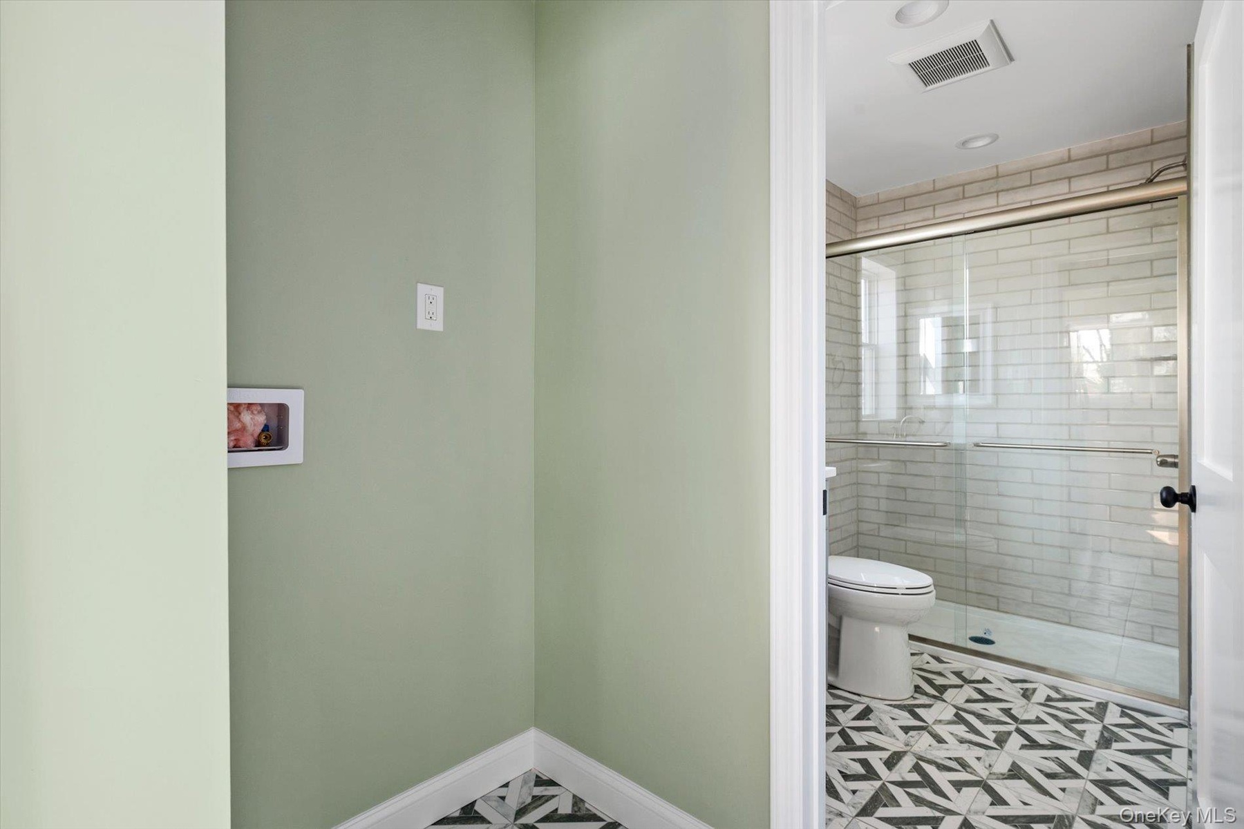 Bathroom featuring a shower stall and toilet