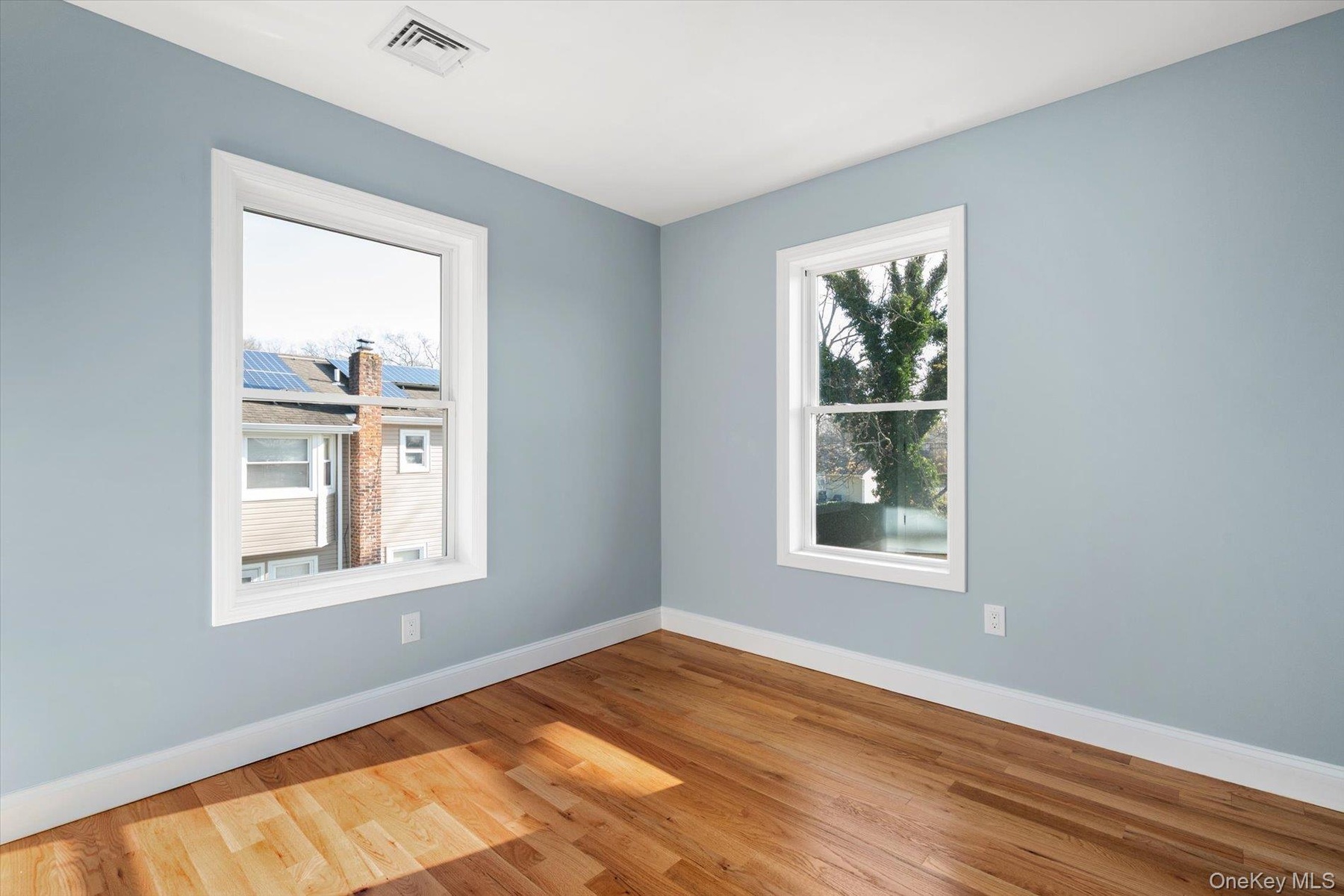 Spare room with baseboards and wood finished floors