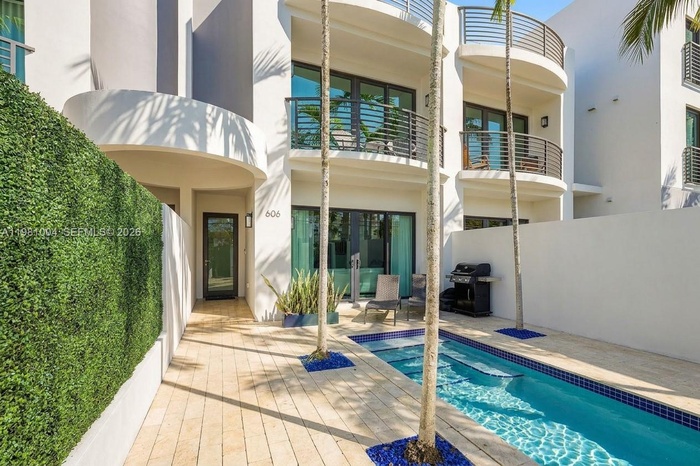 private gated courtyard entry, lush landscaping, sparkling pool

