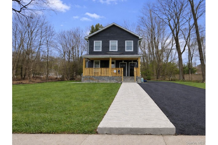 View of front facade with a porch and a front yard