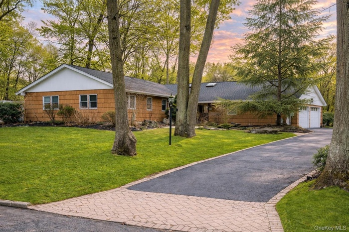 Single story home with a yard, a garage, and asphalt driveway
