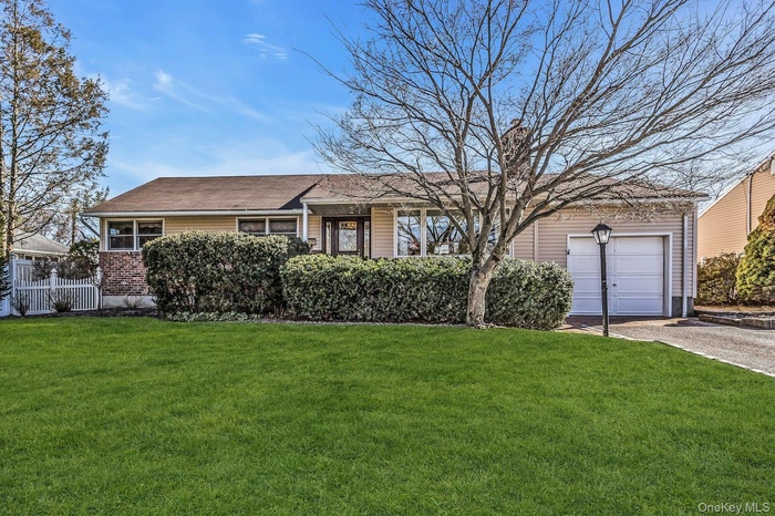 Single story home with a front lawn, driveway, and a garage