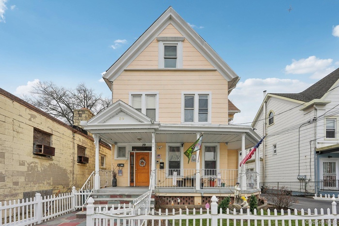 View of front of house featuring covered porch, a fenced front yard