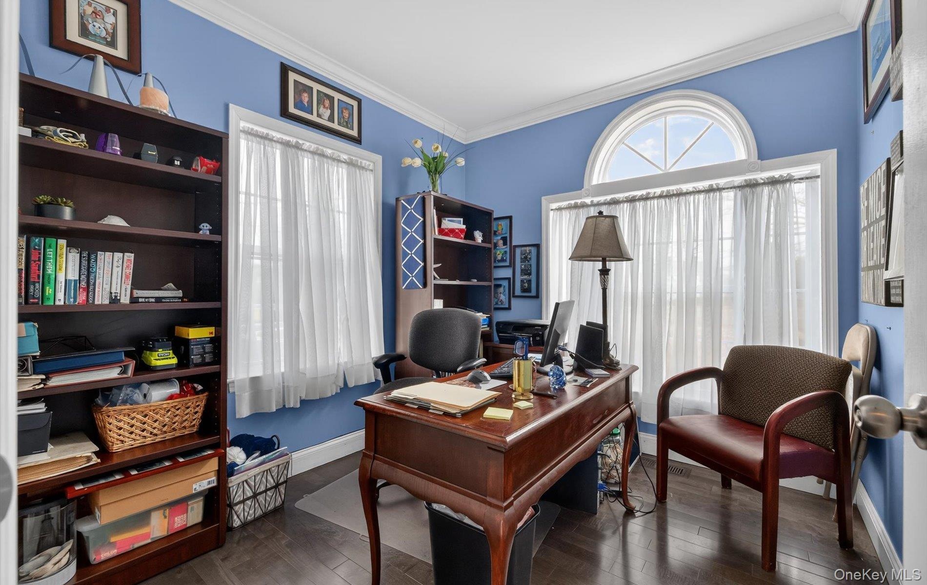 Office space with dark wood-style flooring and ornamental molding