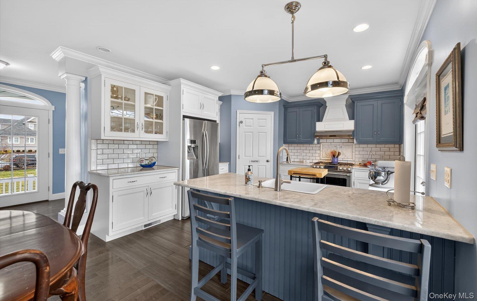 Kitchen with wine cooler, light stone counters, tasteful backsplash, glass insert cabinets, and stainless steel stove