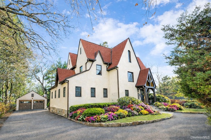 The lush grounds offer exceptional privacy and future potential, highlighted by a sophisticated circular driveway framed by the original stone wall, a