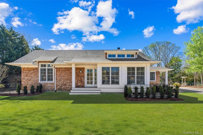 Front of property with a lawn, fence, and roof with shingles