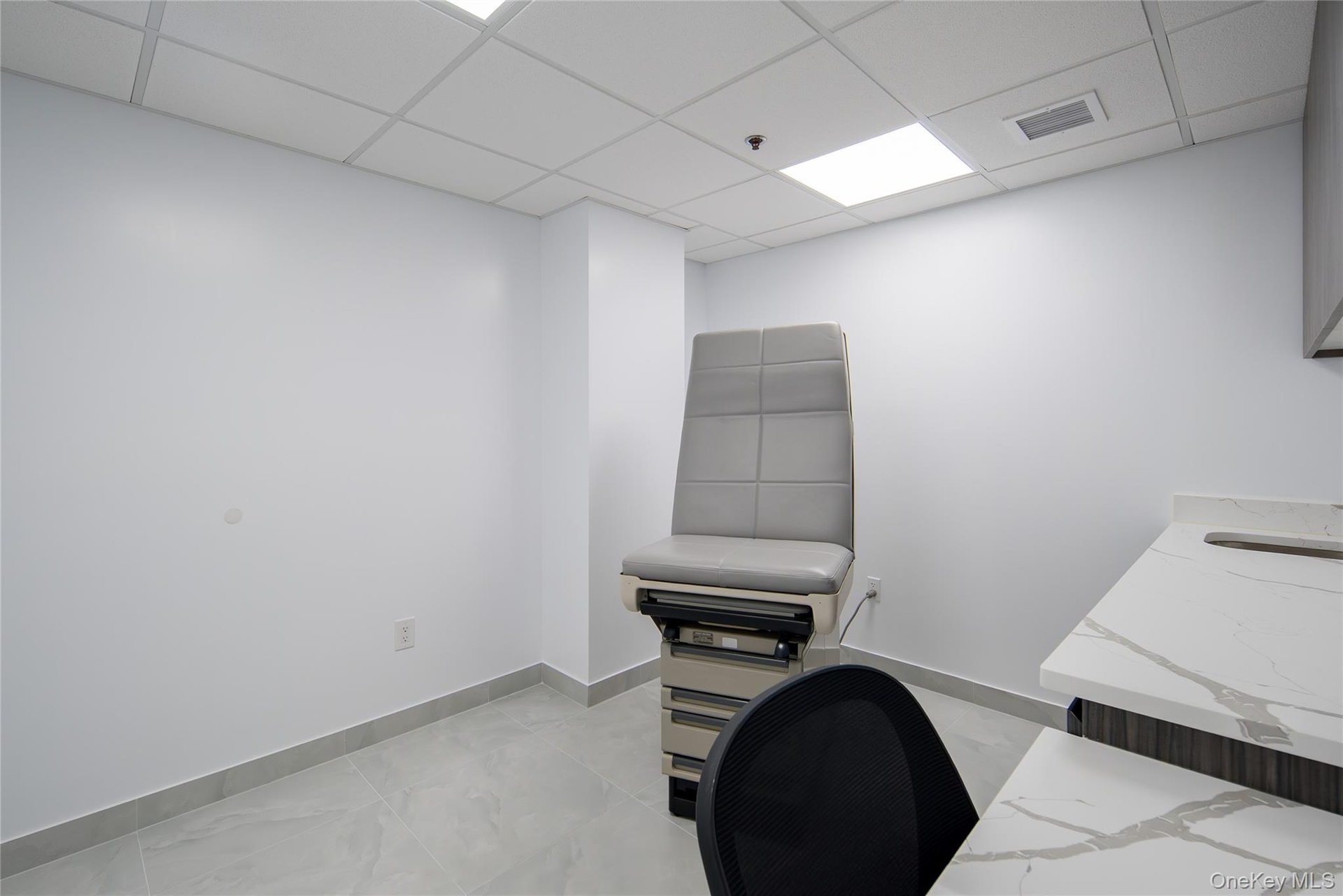 Office space featuring baseboards and a paneled ceiling
