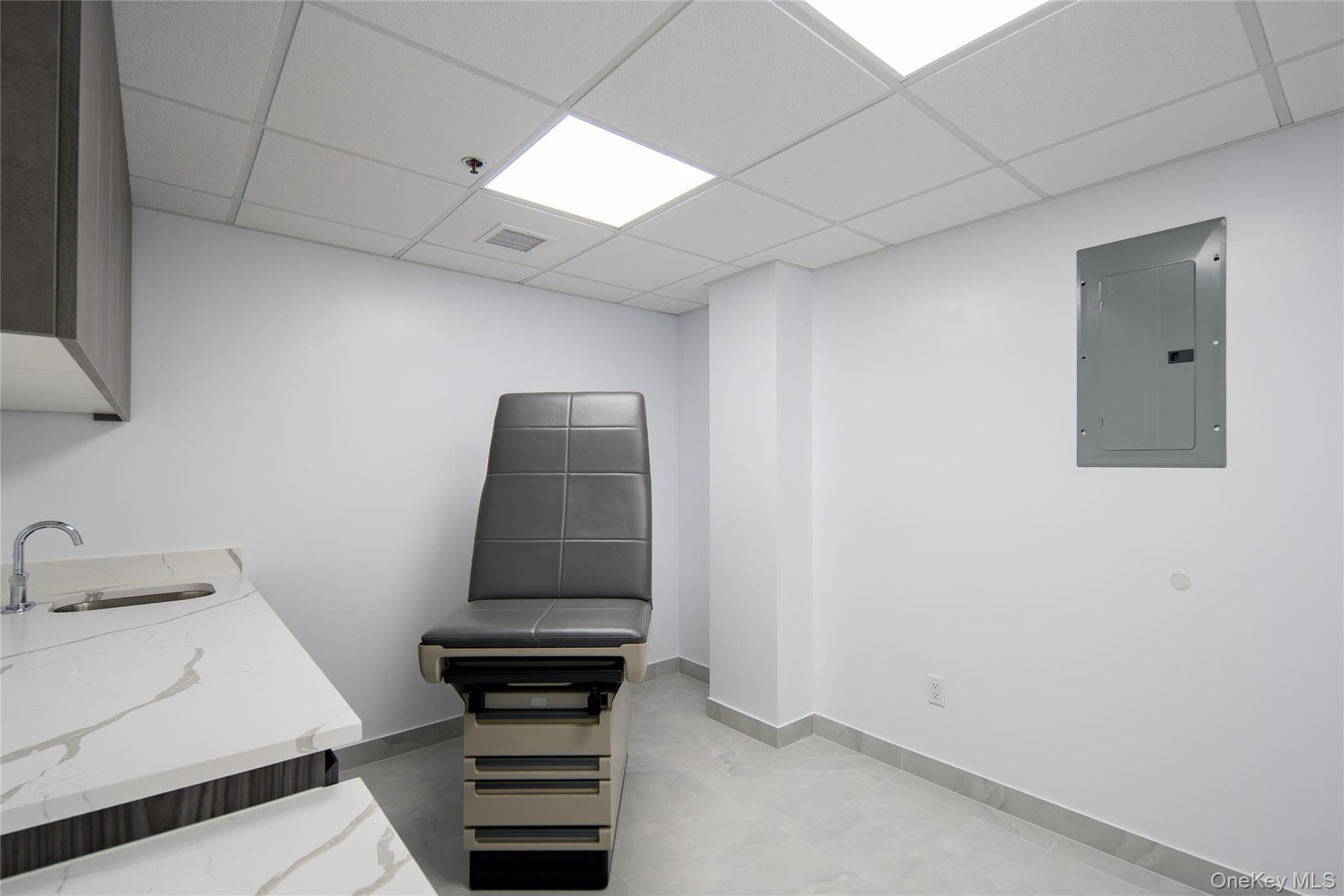 Miscellaneous room featuring electric panel and a paneled ceiling