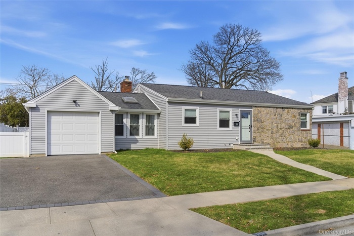 Ranch-style house with an attached garage, asphalt driveway.