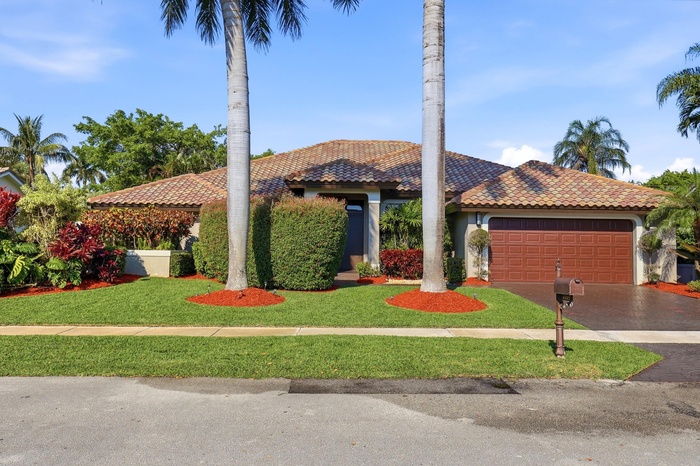 Beautiful 5 bedroom, 3.5 bathroom house highlighted by a large driveway, two car garage, and impeccably maintained landscaping framed by mature palms 