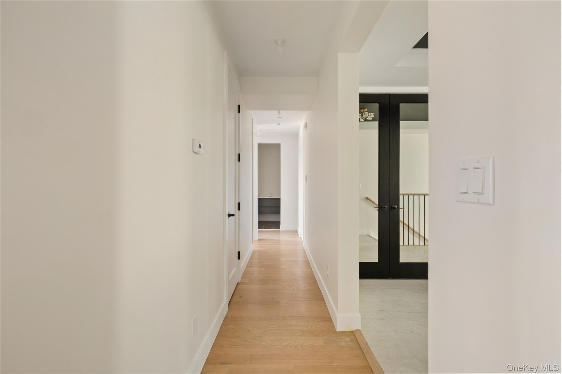 Hallway featuring light wood-type flooring and french doors