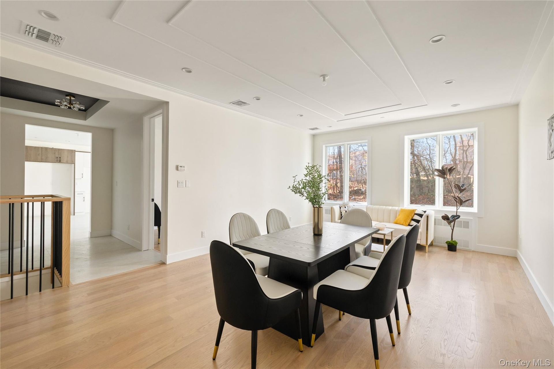 Dining area with light wood-style flooring, radiator heating unit, and recessed lighting