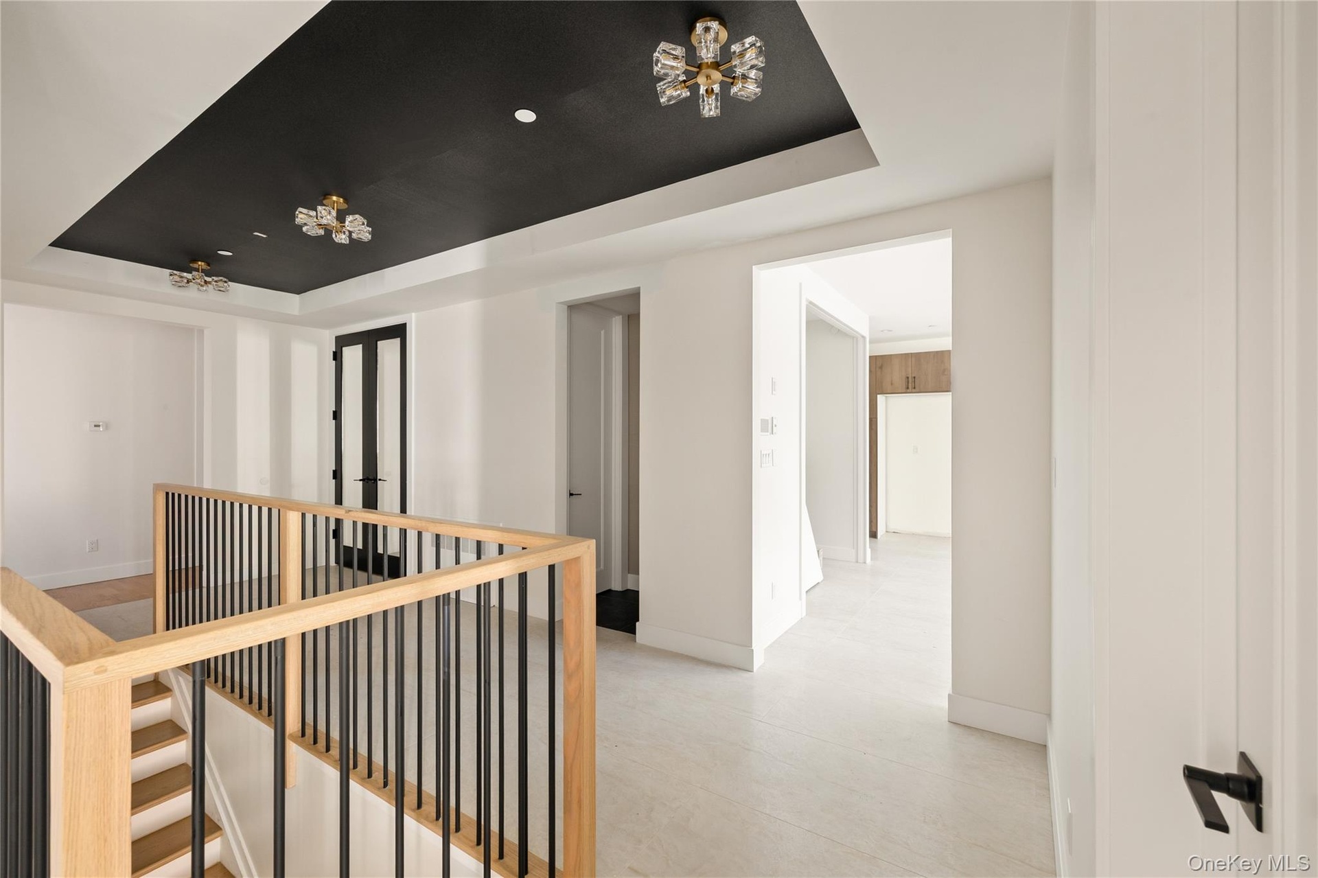 Corridor featuring a raised ceiling and an upstairs landing