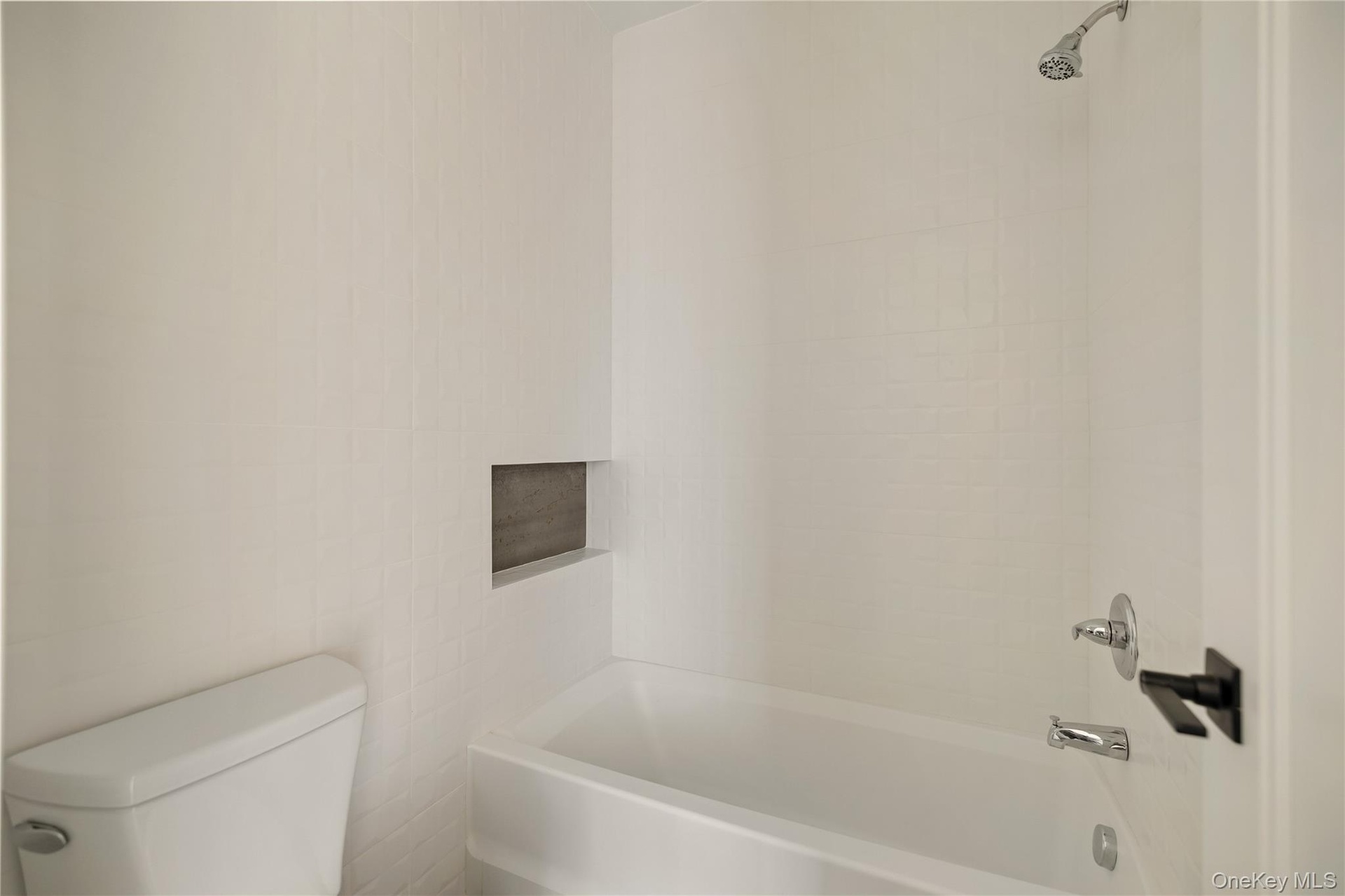Bathroom featuring tub / shower combination and toilet