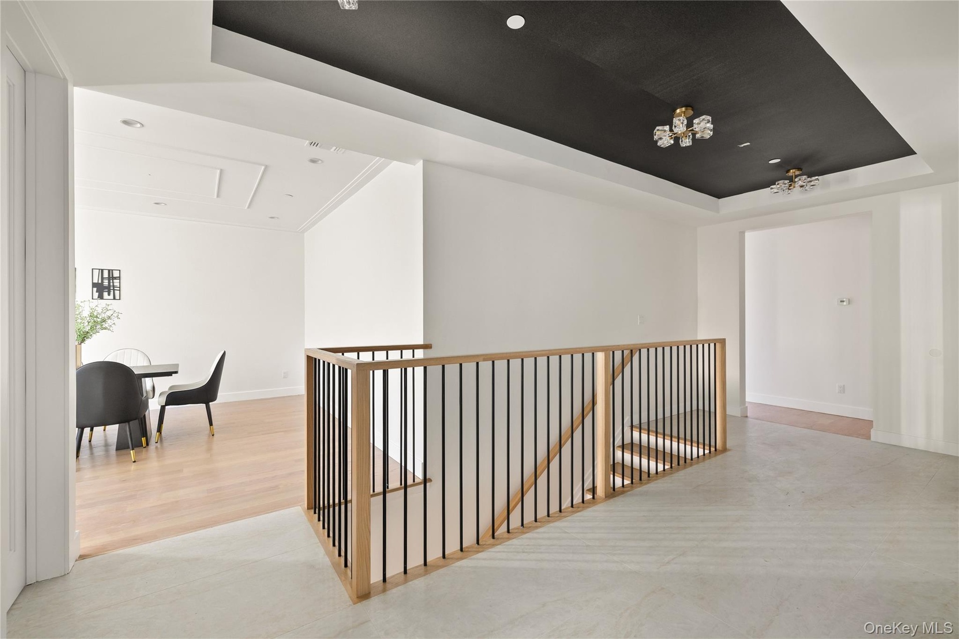 Hall featuring a raised ceiling, an upstairs landing, recessed lighting, and light wood-type flooring