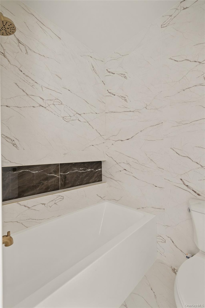 Full bath with toilet and marble tiled floors