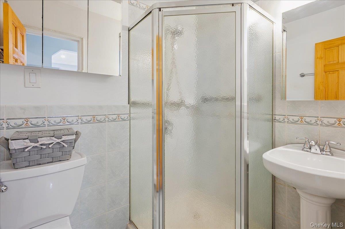 Full primary bathroom with tile walls and a shower stall