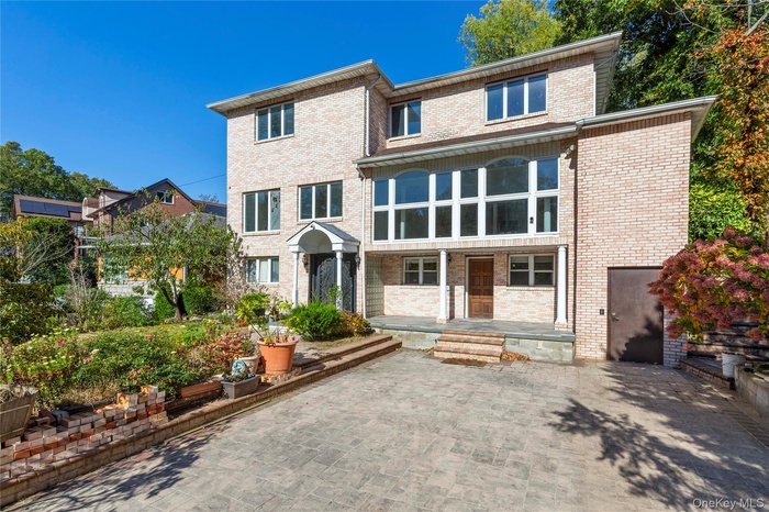 View of front of home with brick siding and a patio area