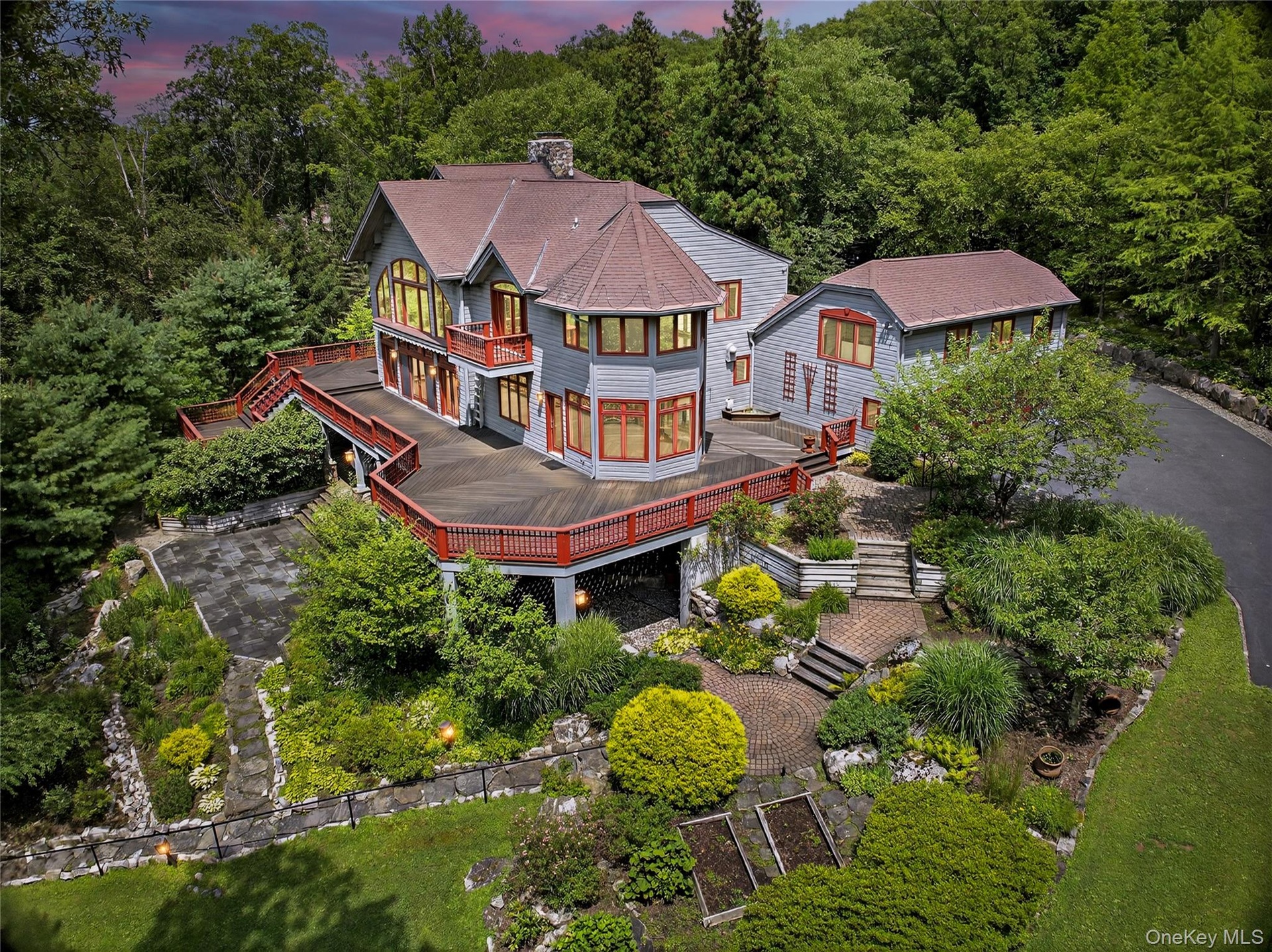 Back of property at dusk with a balcony, stairs, a wooden deck, roof with shingles, and a chimney