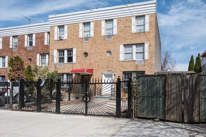 View of front of home featuring a gate, a fenced front yard, and brick siding