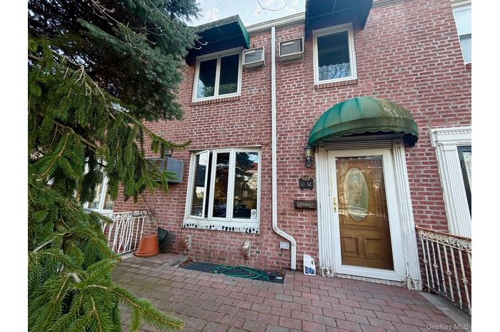 View of exterior entry with brick siding and a patio area