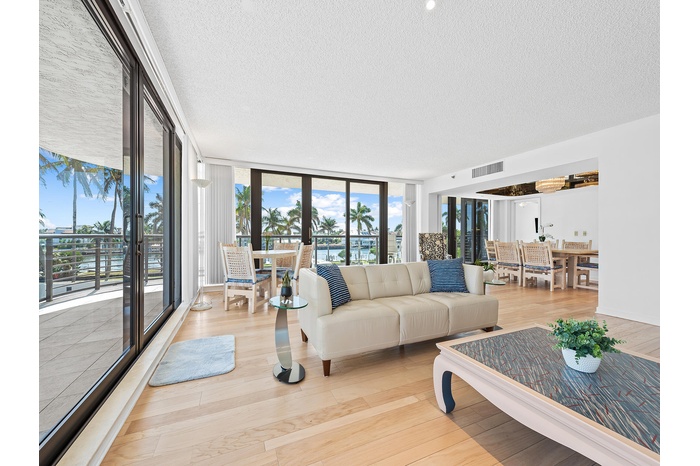 Large open living room surrounded by deep balcony and floor to ceiling windows