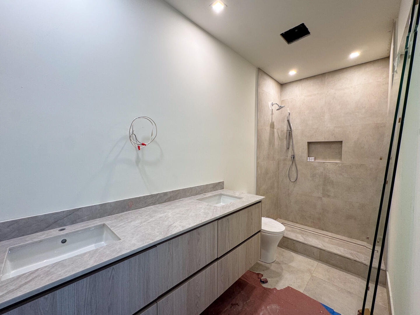 (as of April 8, 2026) a shared bathroom services both guest bedrooms on the second level with a double vanity and framess glass shower, also controlle