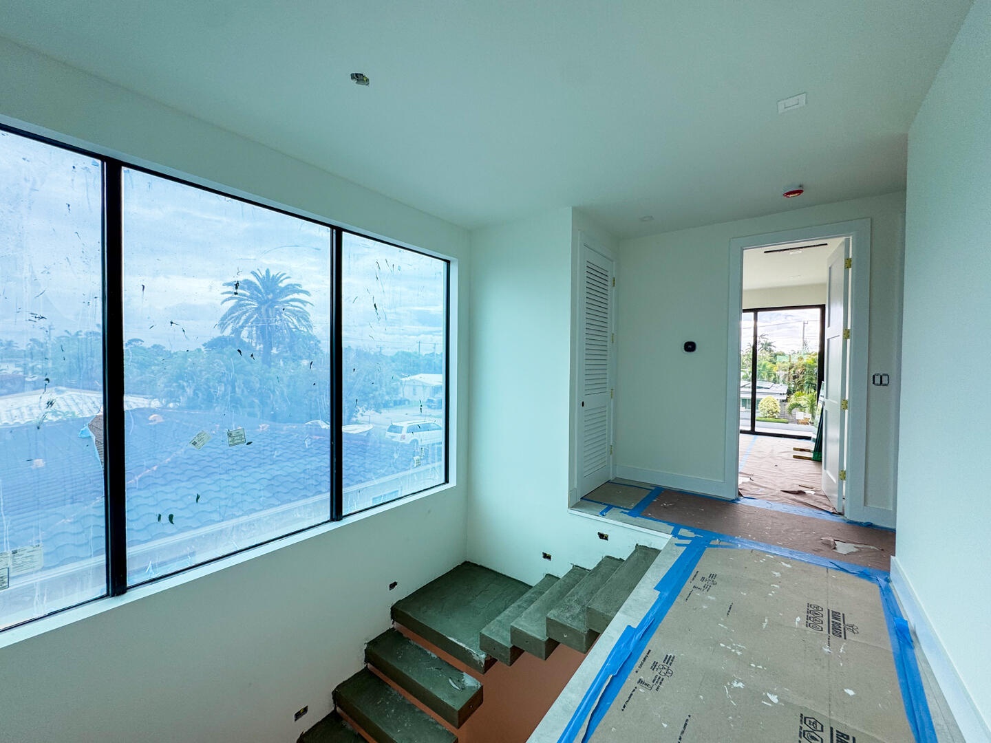 (as of April 8, 2026) the second level is seamlessly connected by the floating concrete staircase, with light pouring in from the full-height picture 
