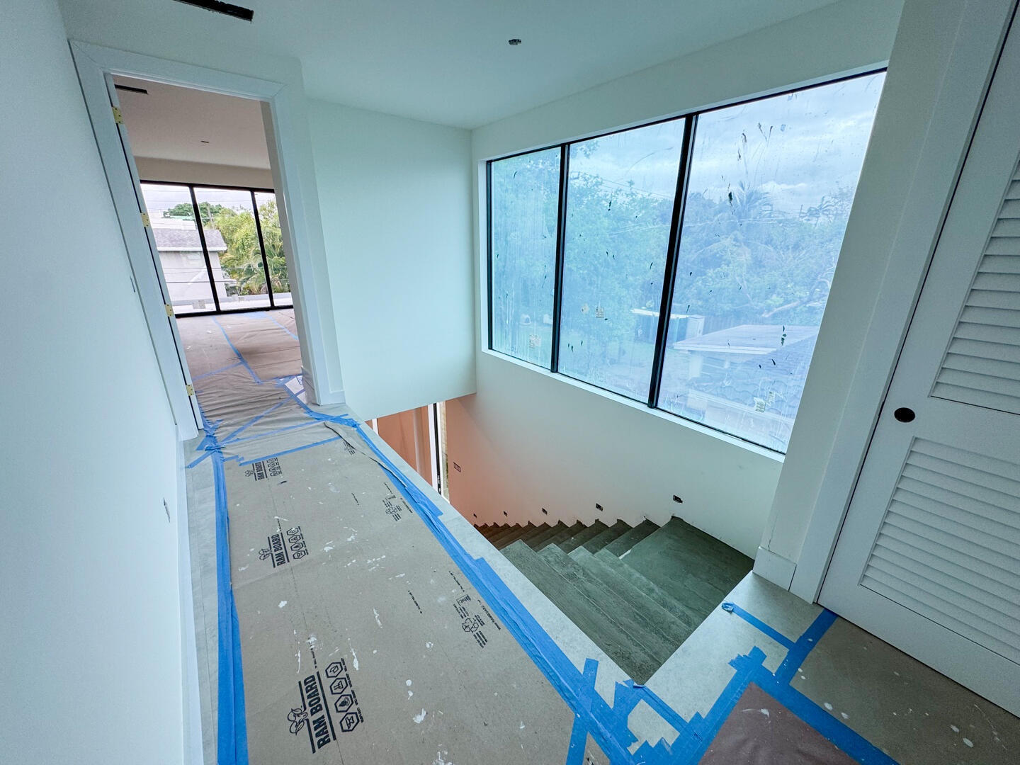 (as of April 8, 2026) the second level is seamlessly connected by the floating concrete staircase, with light pouring in from the full-height picture 